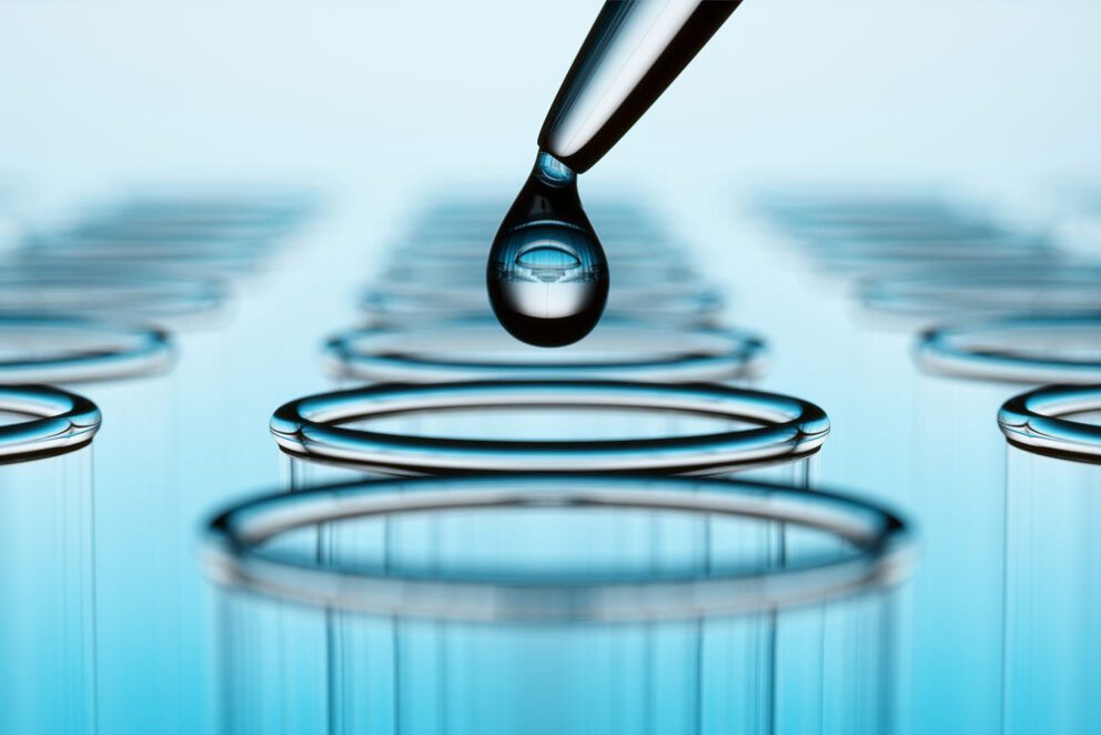 A droplet of water going into a glass beaker